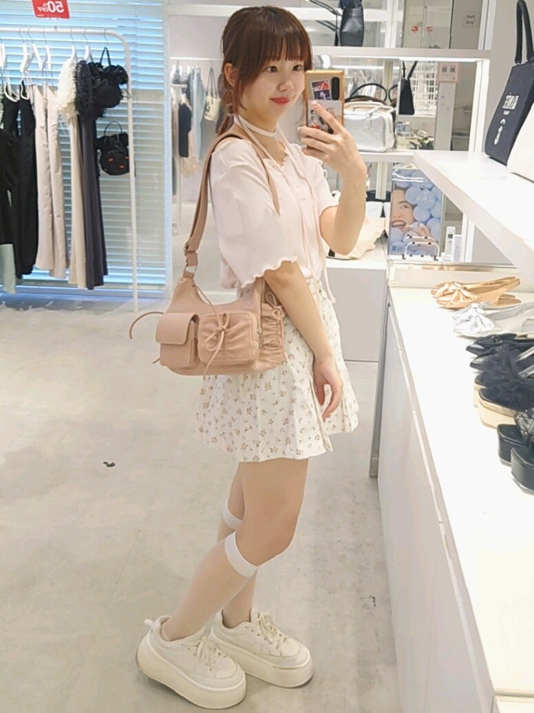 ピンク系のTシャツ/カットソー、ホワイト系のデニムスカート、ピンク系のショルダーバッグを着用したレディースの夏コーディネートの3枚目の写真