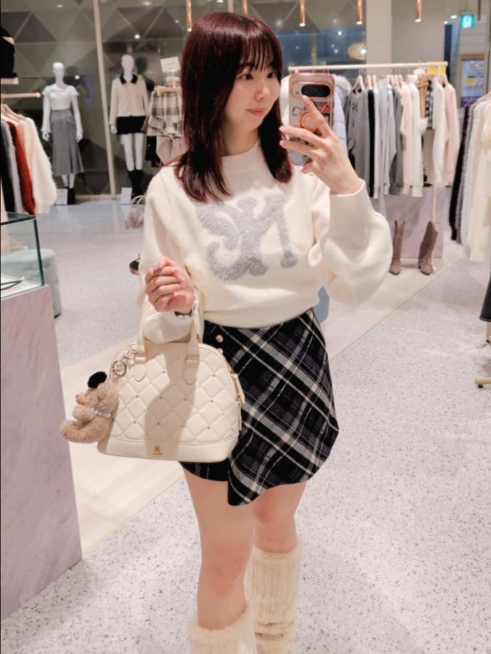 ホワイト系のダウンジャケット/コート、ホワイト系のニット/セーター、ブラック系のスカートを着用したレディースの冬コーディネートの2枚目の写真