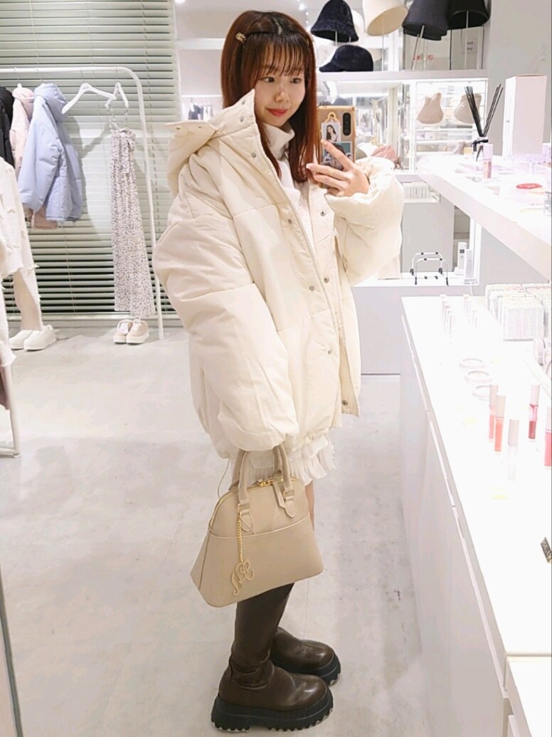 ホワイト系のダウンジャケット/コート、ホワイト系のワンピース、ブラウン系のブーツを着用したレディースの冬コーディネートの3枚目の写真