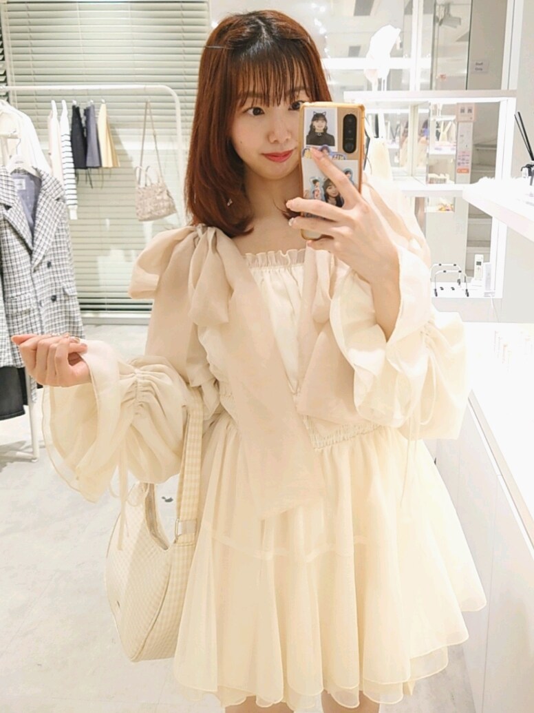 ホワイト系のシャツ/ブラウス、ホワイト系のブーツ、ベージュ系のショルダーバッグを着用したレディースの春コーディネートの2枚目の写真