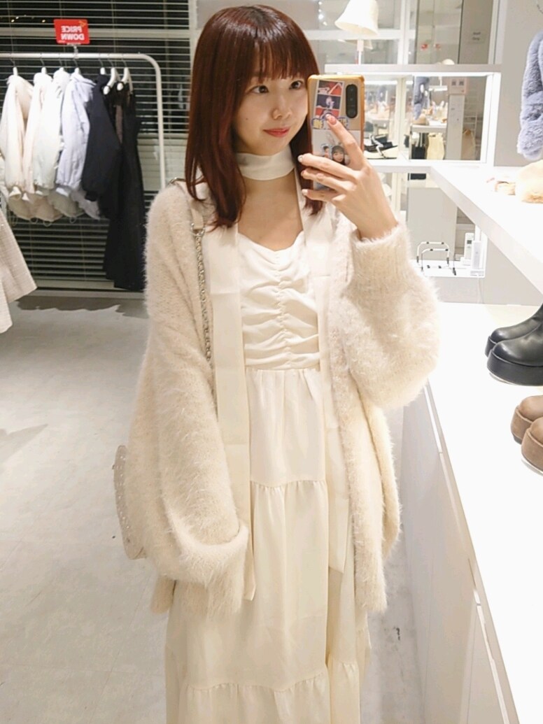 ピンク系のカーディガン/ボレロ、ホワイト系のワンピース、ピンク系のショルダーバッグを着用したレディースの冬コーディネートの2枚目の写真