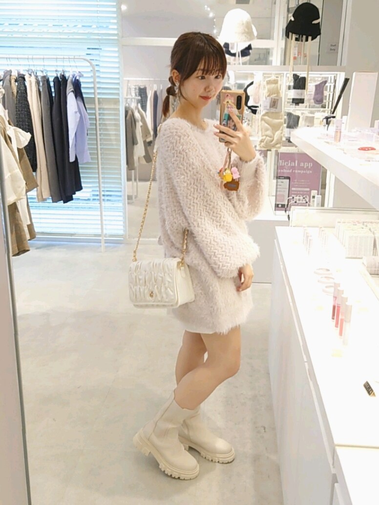 ピンク系のカーディガン/ボレロ、ホワイト系のスカート、ホワイト系のショルダーバッグを着用したレディースの秋コーディネートの3枚目の写真