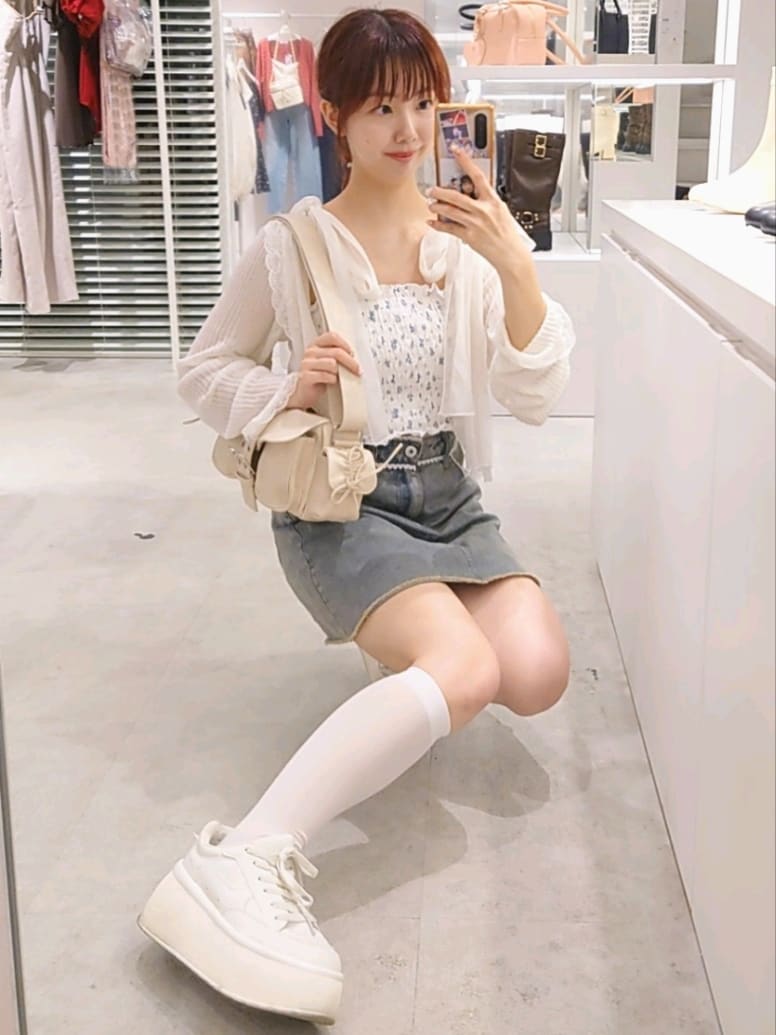 ホワイト系のカーディガン/ボレロ、ホワイト系のショルダーバッグ、ホワイト系のスニーカーを着用したレディースの秋コーディネートの4枚目の写真