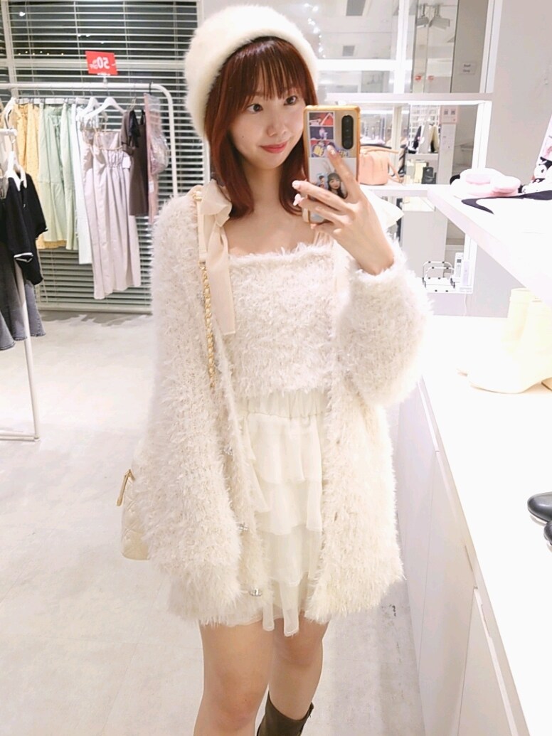 ホワイト系のカーディガン/ボレロ、ホワイト系のキャミソール、ホワイト系のスカートを着用したレディースの秋コーディネートの2枚目の写真