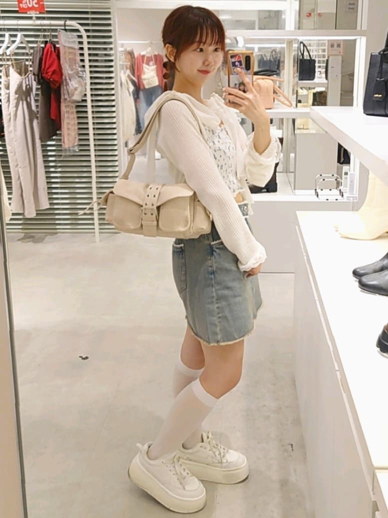 ホワイト系のカーディガン/ボレロ、ホワイト系のショルダーバッグ、ホワイト系のスニーカーを着用したレディースの秋コーディネートの3枚目の写真