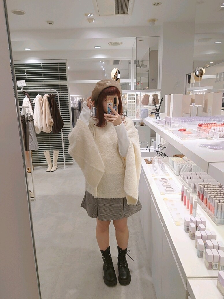 ホワイト系のニット/セーター、ホワイト系のTシャツ/カットソー、ブラック系のスカートを着用したレディースの秋コーディネートの2枚目の写真