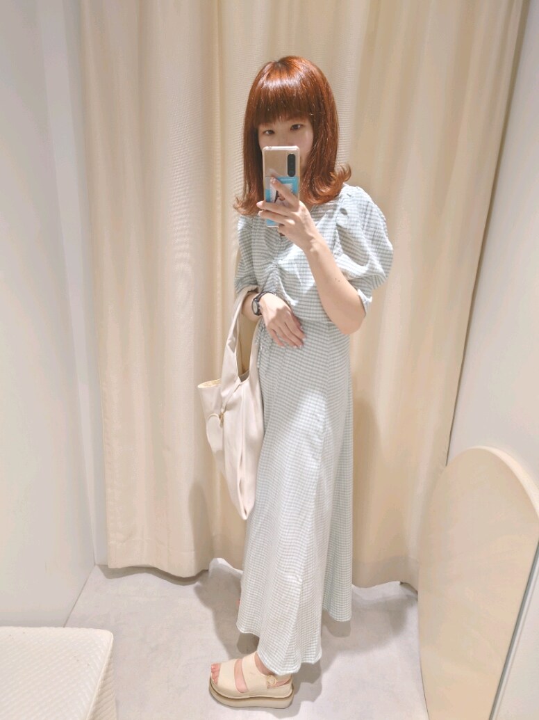 グリーン系のワンピース、ホワイト系のショルダーバッグを着用したレディースの夏コーディネートの3枚目の写真