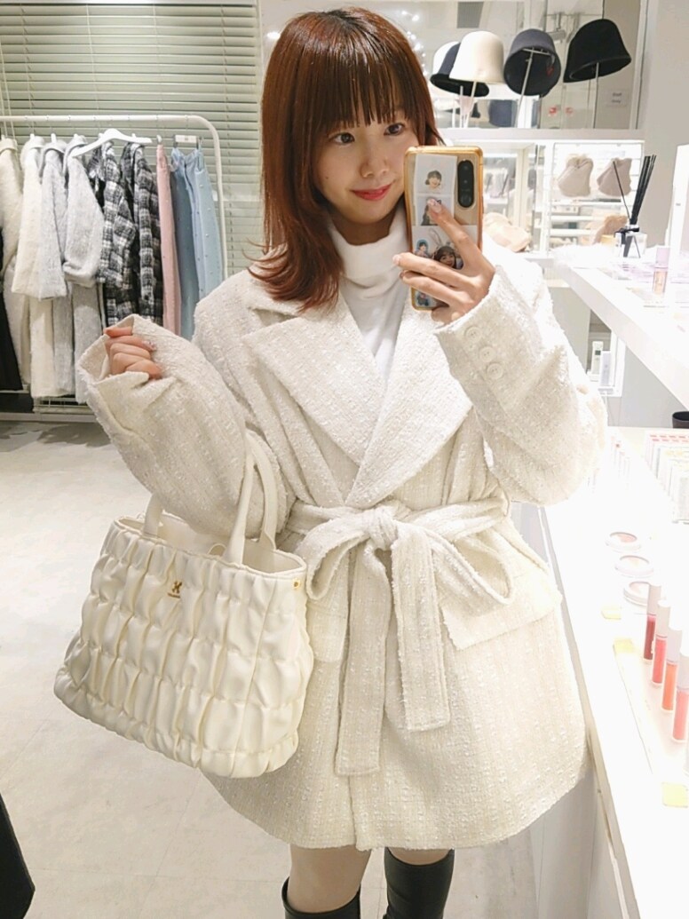 ホワイト系のテーラードジャケット、ホワイト系のハンドバッグを着用したレディースの冬コーディネートの2枚目の写真