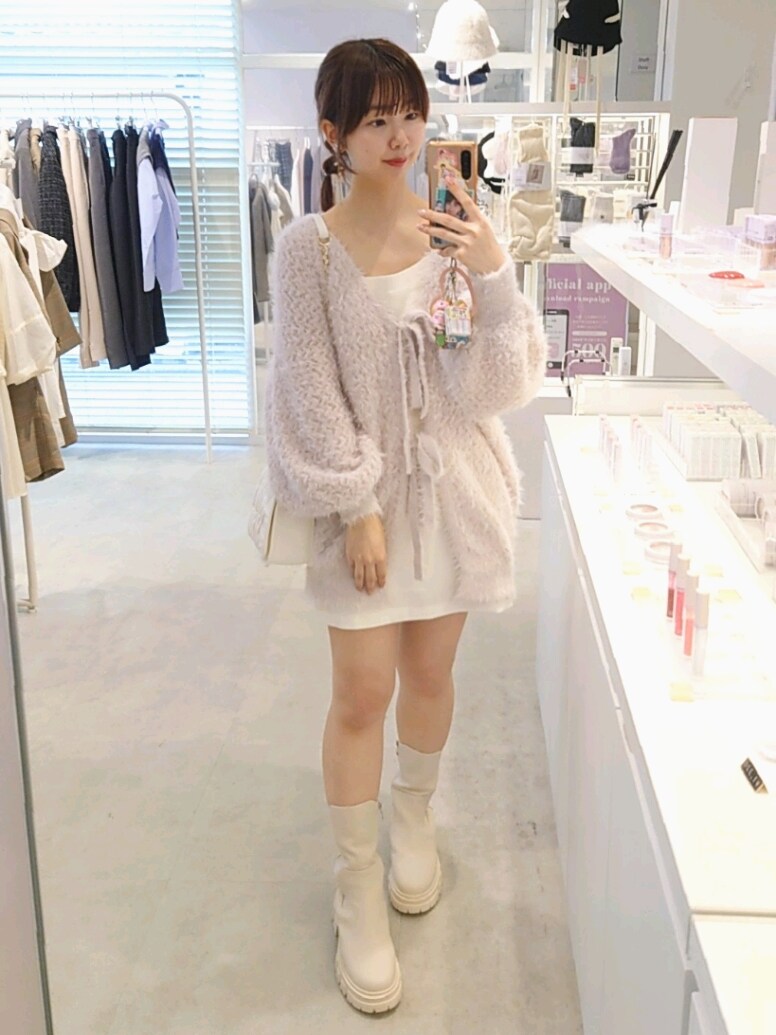 ピンク系のカーディガン/ボレロ、ホワイト系のスカート、ホワイト系のショルダーバッグを着用したレディースの秋コーディネートの2枚目の写真