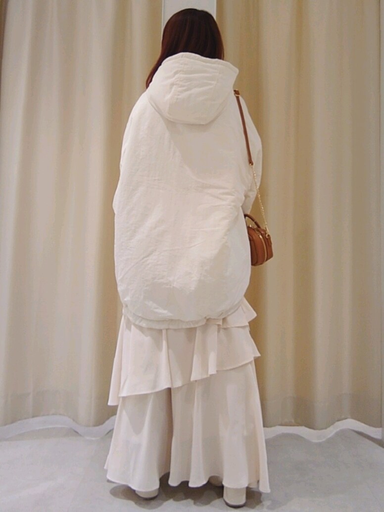 ホワイト系のブルゾン、イエロー系のボストンバッグ、ホワイト系のスカートを着用したレディースの冬コーディネートの4枚目の写真