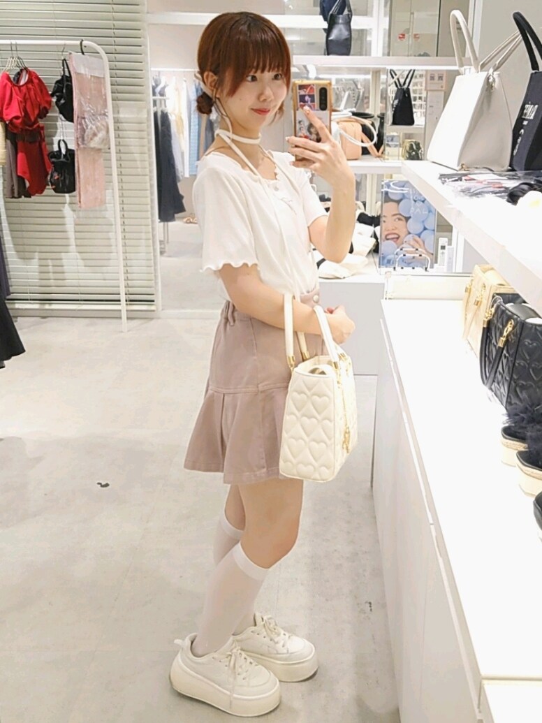 ホワイト系のTシャツ/カットソー、ピンク系のスカート、ホワイト系のスニーカーを着用したレディースの夏コーディネートの3枚目の写真
