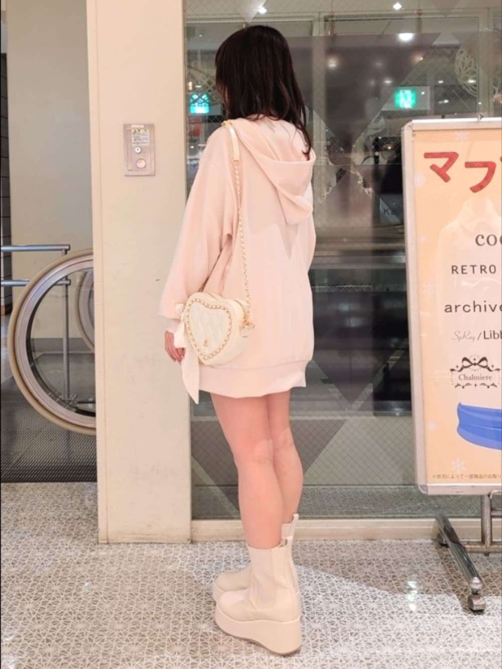 ブルー系のパーカー、ホワイト系のスカート、ホワイト系のブーツを着用したレディースの冬コーディネートの4枚目の写真