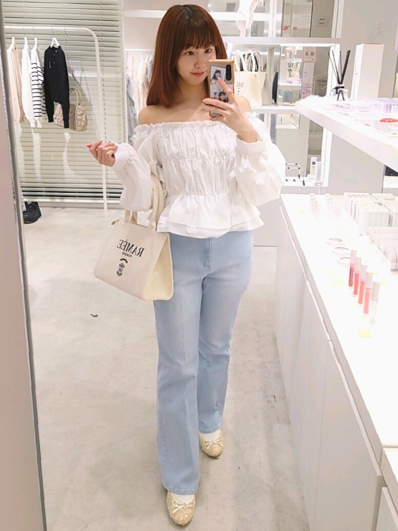 ホワイト系のシャツ/ブラウス、ブルー系のデニムパンツ、ホワイト系のトートバッグを着用したレディースの春コーディネートの2枚目の写真