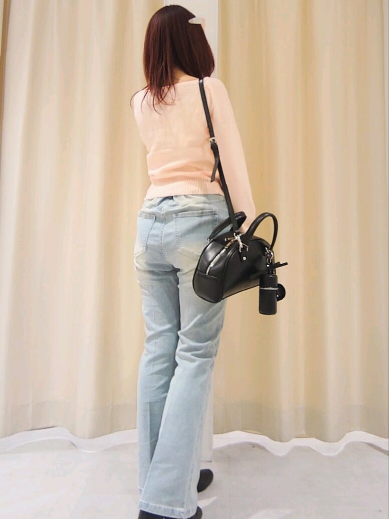 ピンク系のニット/セーター、ブルー系のデニムパンツ、ブラック系のハンドバッグを着用したレディースの冬コーディネートの6枚目の写真