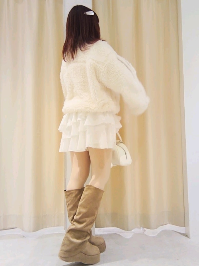 ホワイト系のブルゾン、ホワイト系のスカート、ホワイト系のハンドバッグを着用したレディースの冬コーディネートの6枚目の写真