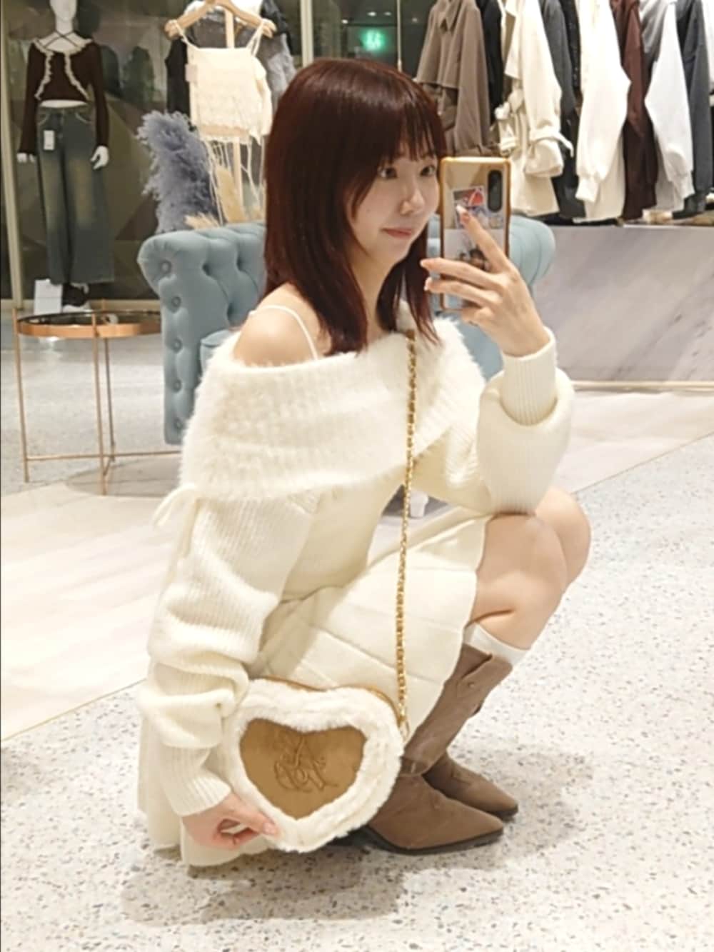 ホワイト系のワンピース、ベージュ系のショルダーバッグ、ベージュ系のブーツを着用したレディースの秋コーディネートの2枚目の写真