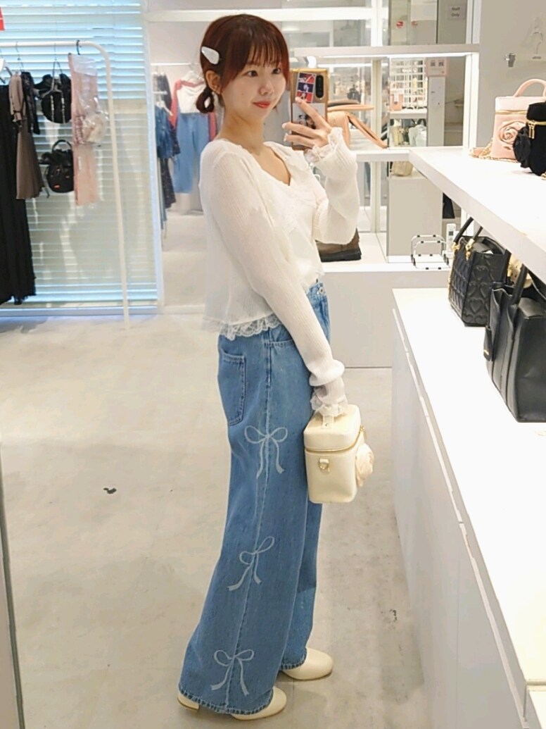 ホワイト系のカーディガン/ボレロ、ブルー系のデニムパンツ、ホワイト系のショルダーバッグを着用したレディースの夏コーディネートの3枚目の写真