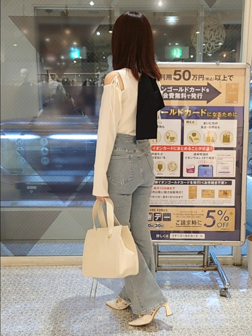 ホワイト系のニット/セーター、ブルー系のデニムパンツ、ホワイト系のパンプスを着用したレディースの秋コーディネートの3枚目の写真