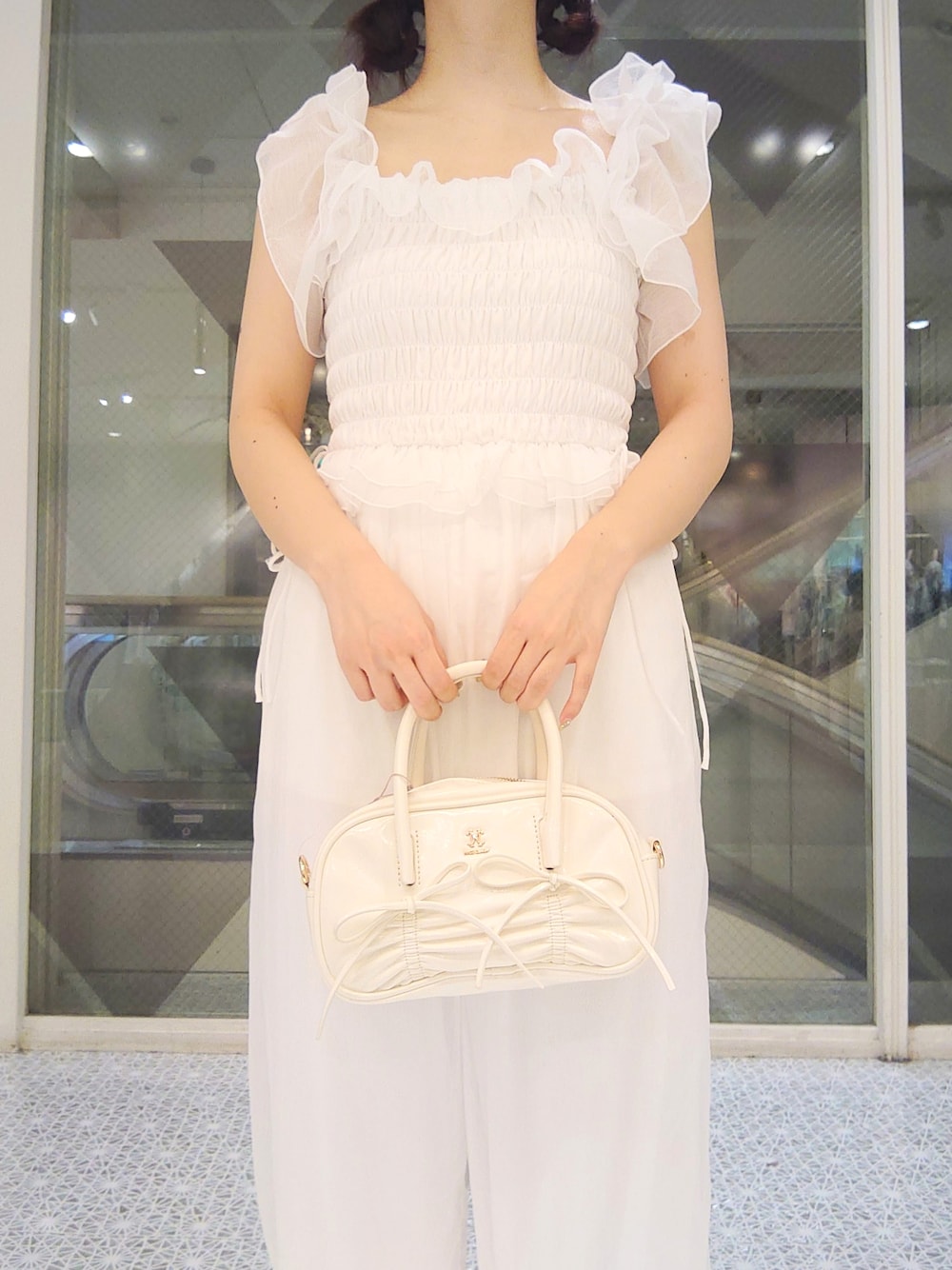 ホワイト系のその他パンツ、ホワイト系のショルダーバッグ、ホワイト系のサンダルを着用したレディースの夏コーディネートの2枚目の写真