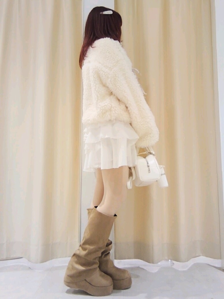 ホワイト系のブルゾン、ホワイト系のスカート、ホワイト系のハンドバッグを着用したレディースの冬コーディネートの4枚目の写真