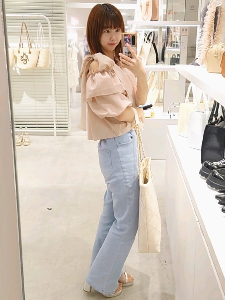 ピンク系のシャツ/ブラウス、ホワイト系のトートバッグ、ブルー系のデニムパンツを着用したレディースの夏コーディネートの3枚目の写真