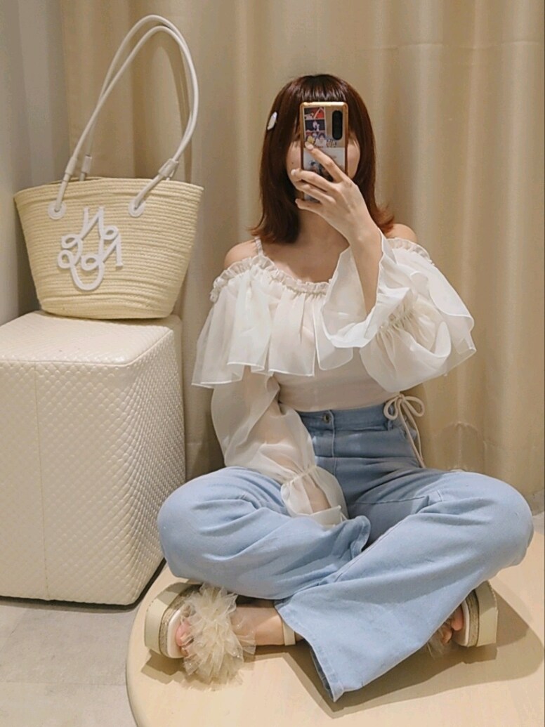 ホワイト系のサンダル、ブルー系のデニムパンツ、ホワイト系のトートバッグを着用したレディースの夏コーディネートの2枚目の写真