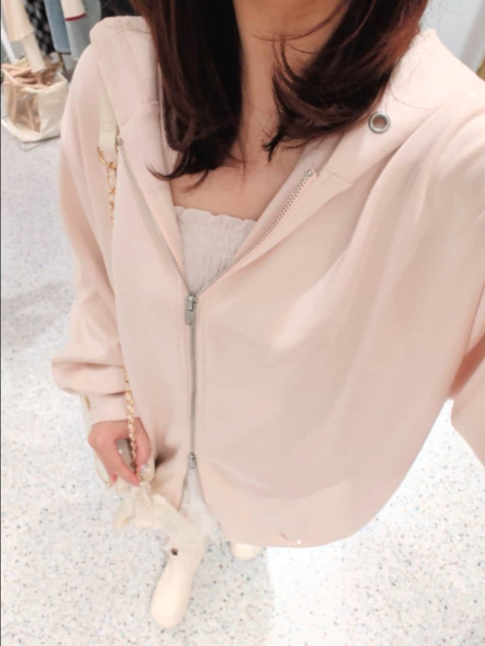 ブルー系のパーカー、ホワイト系のスカート、ホワイト系のブーツを着用したレディースの冬コーディネートの2枚目の写真