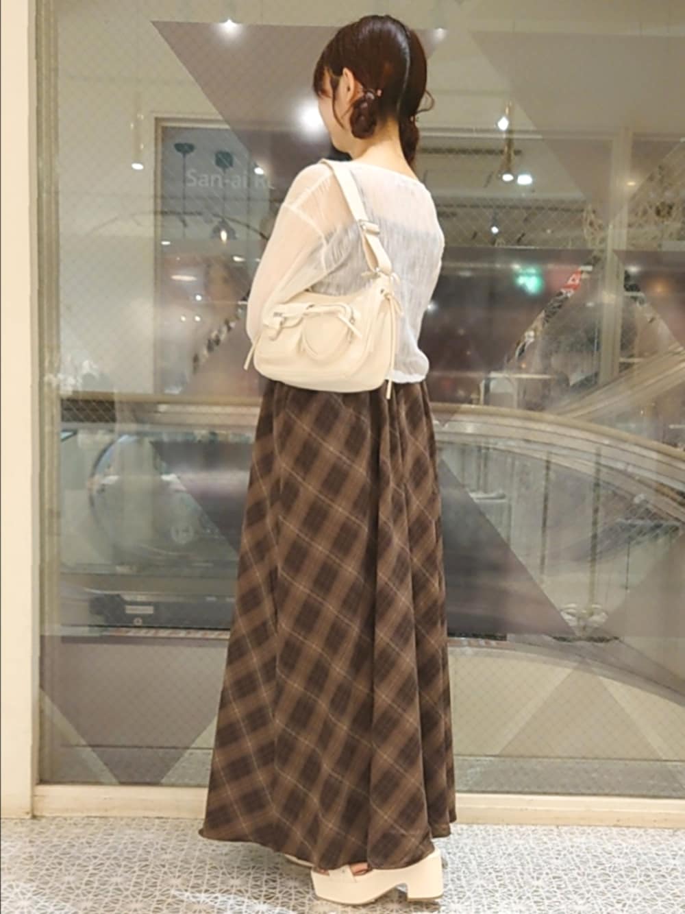 ホワイト系のカーディガン/ボレロ、ブラウン系のワンピース、ホワイト系のショルダーバッグを着用したレディースの夏コーディネートの2枚目の写真