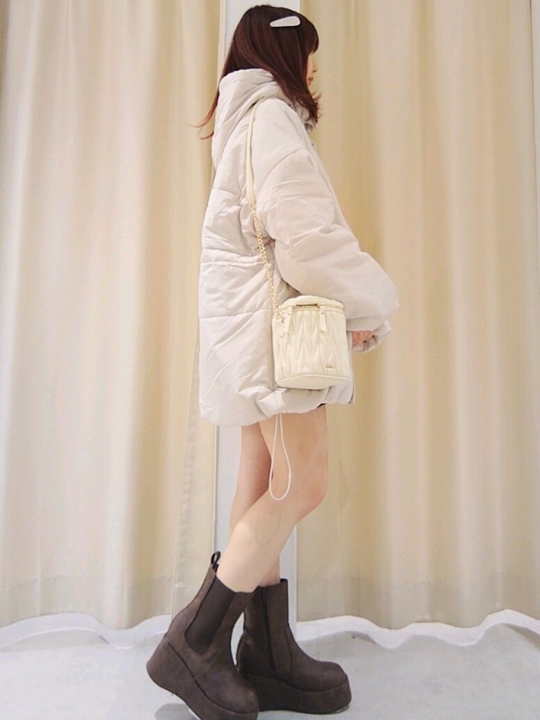 ベージュ系のダウンジャケット/コート、ホワイト系のショルダーバッグ、ブラウン系のブーツを着用したレディースの冬コーディネートの3枚目の写真