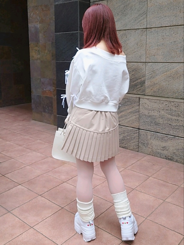 ホワイト系のスウェット、ベージュ系のスカート、ホワイト系のスニーカーを着用したレディースの春コーディネートの3枚目の写真