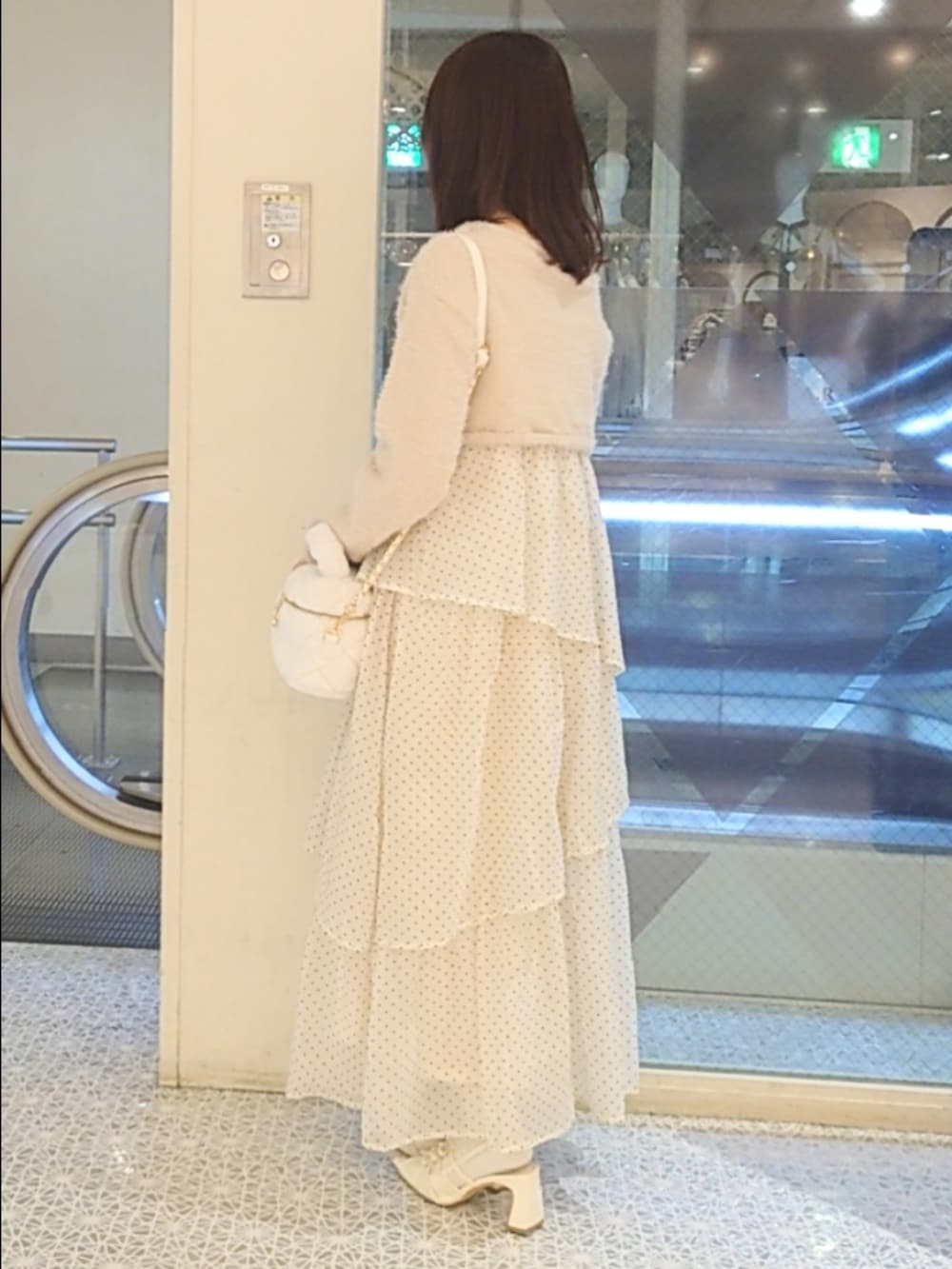 ベージュ系のワンピース、ホワイト系のショルダーバッグ、ホワイト系のパンプスを着用したレディースの秋コーディネートの3枚目の写真