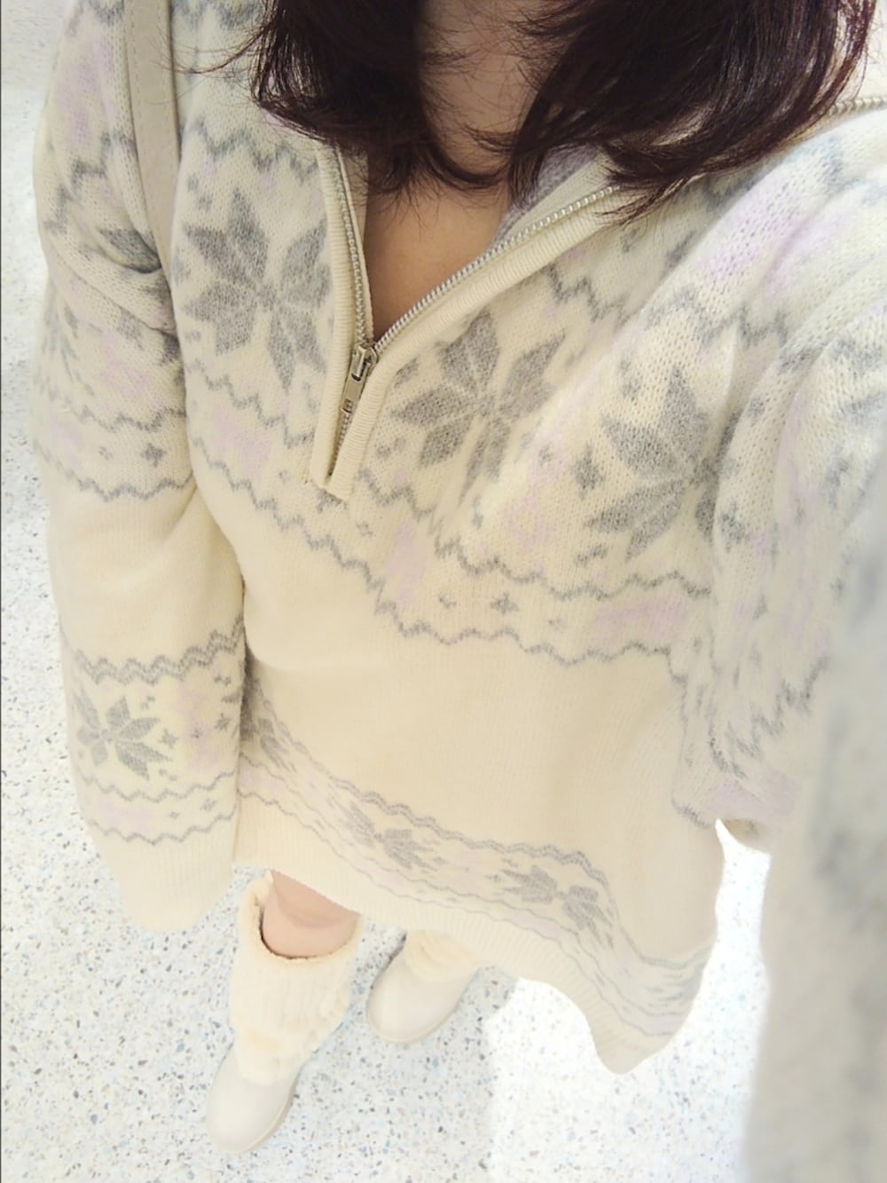 ホワイト系のニット/セーター、ホワイト系のボストンバッグ、ベージュ系のブーツを着用したレディースの冬コーディネートの3枚目の写真