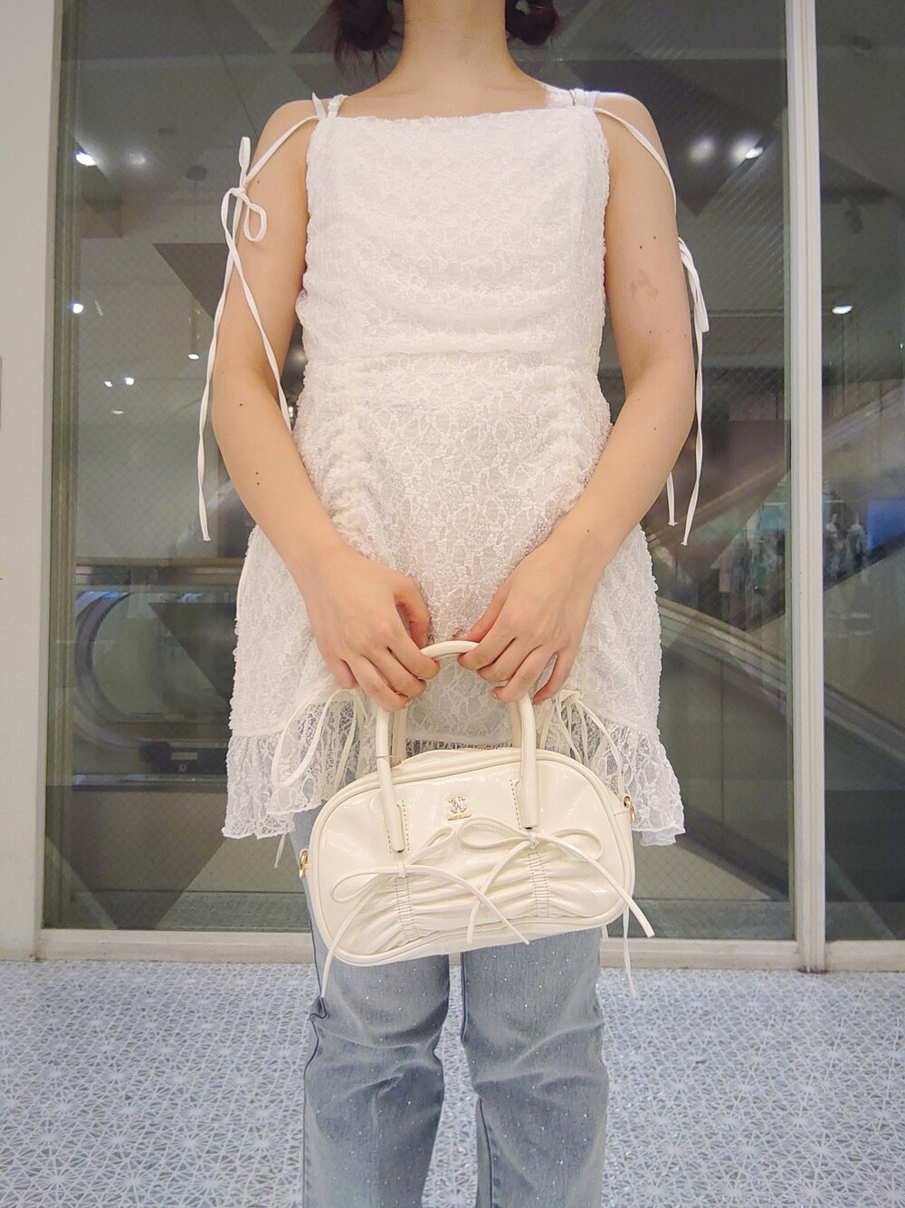 ホワイト系のシャツ/ブラウス、ブルー系のデニムパンツ、ホワイト系のショルダーバッグを着用したレディースの夏コーディネートの2枚目の写真