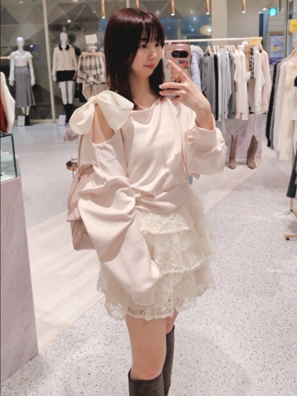 ピンク系のTシャツ/カットソー、ホワイト系のスカート、ピンク系のボストンバッグを着用したレディースの冬コーディネートの2枚目の写真