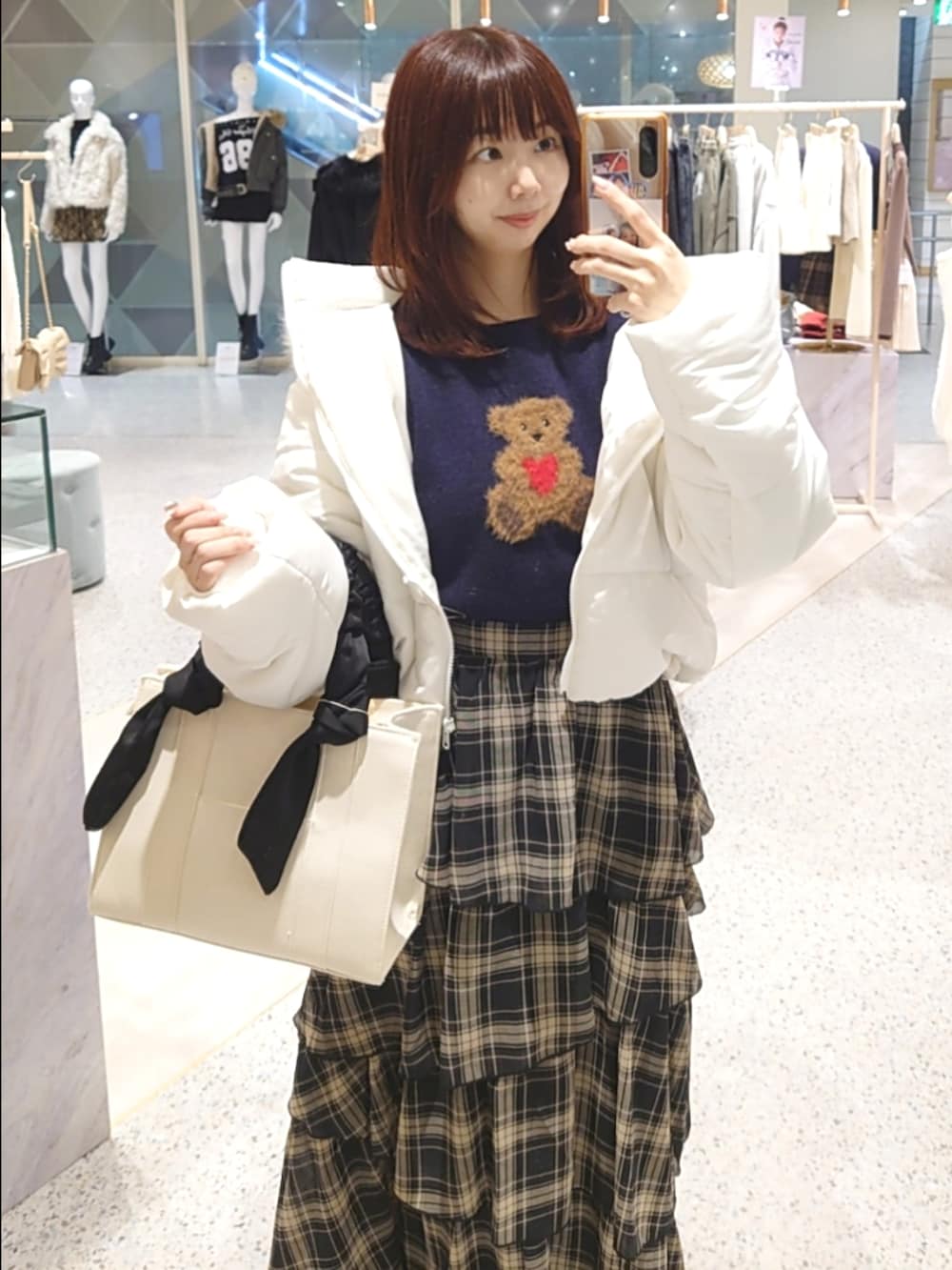 ホワイト系のダウンジャケット/コート、ブルー系のニット/セーター、ブラック系のスカートを着用したレディースの秋コーディネートの2枚目の写真