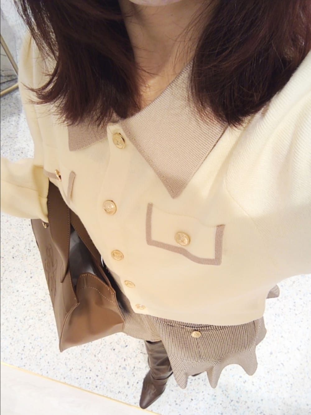 ホワイト系のニット/セーター、ブラウン系のスカート、ブラウン系のブーツを着用したレディースの秋コーディネートの2枚目の写真