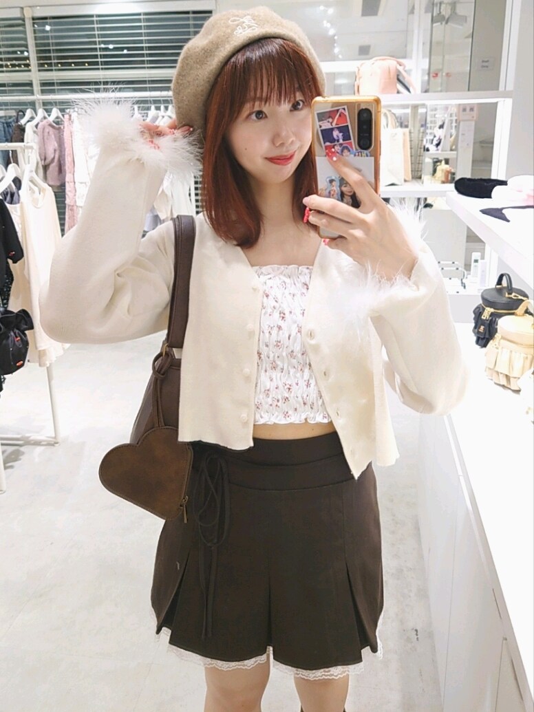 ホワイト系のカーディガン/ボレロ、ホワイト系のキャミソール、ブラウン系のスカートを着用したレディースの秋コーディネートの2枚目の写真