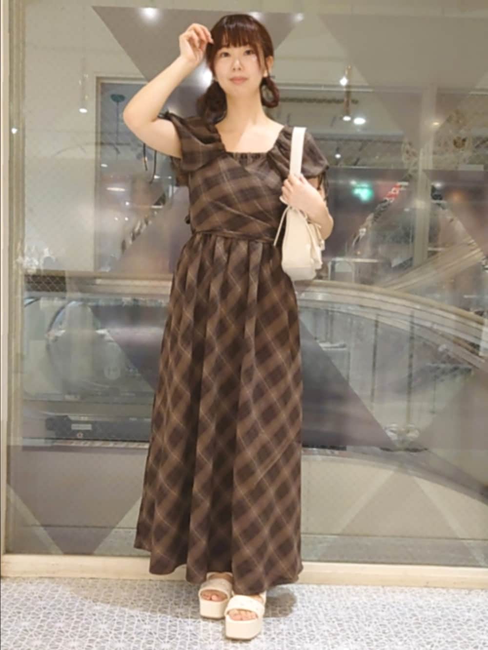 ホワイト系のカーディガン/ボレロ、ブラウン系のワンピース、ホワイト系のショルダーバッグを着用したレディースの夏コーディネートの3枚目の写真