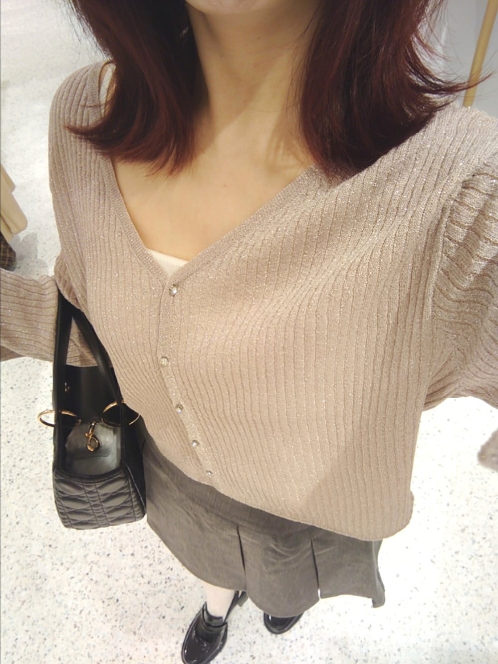 ピンク系のカーディガン/ボレロ、ホワイト系のキャミソール、グレー系のスカートを着用したレディースの秋コーディネートの2枚目の写真