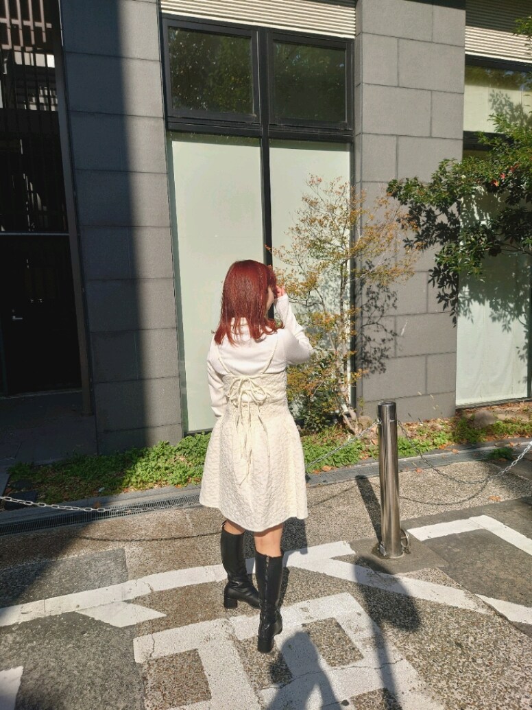 ベージュ系のステンカラーコート、ホワイト系のTシャツ/カットソー、ホワイト系のワンピースを着用したレディースの秋コーディネートの4枚目の写真