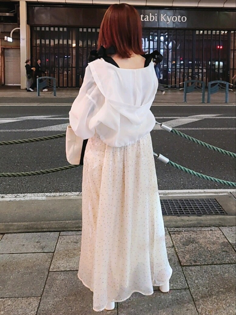 ホワイト系のマウンテンパーカー、ベージュ系のワンピース、ホワイト系のサンダルを着用したレディースの春コーディネートの3枚目の写真