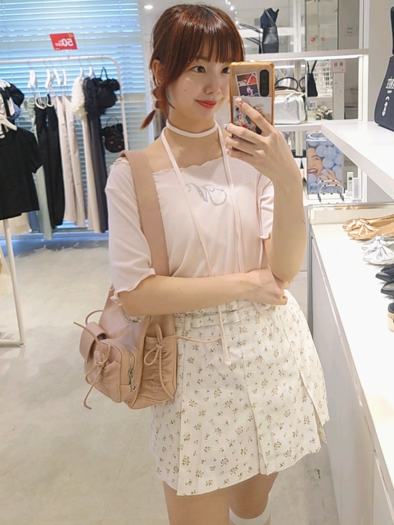 ピンク系のTシャツ/カットソー、ホワイト系のデニムスカート、ピンク系のショルダーバッグを着用したレディースの夏コーディネートの2枚目の写真