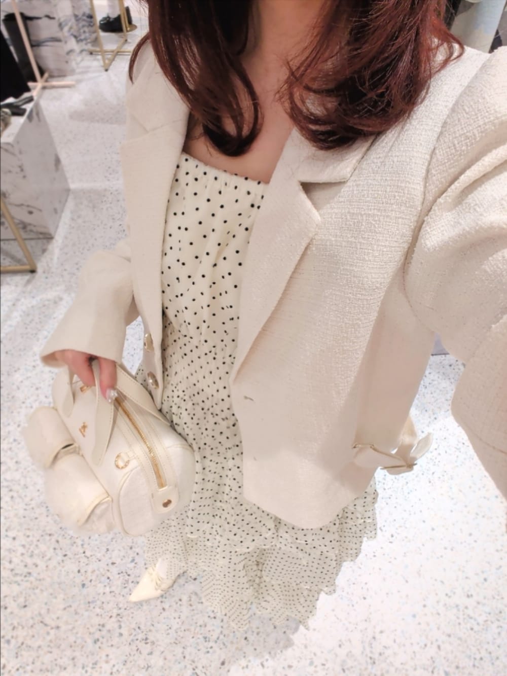 ホワイト系のテーラードジャケット、その他のワンピース、ホワイト系のショルダーバッグを着用したレディースの冬コーディネートの2枚目の写真