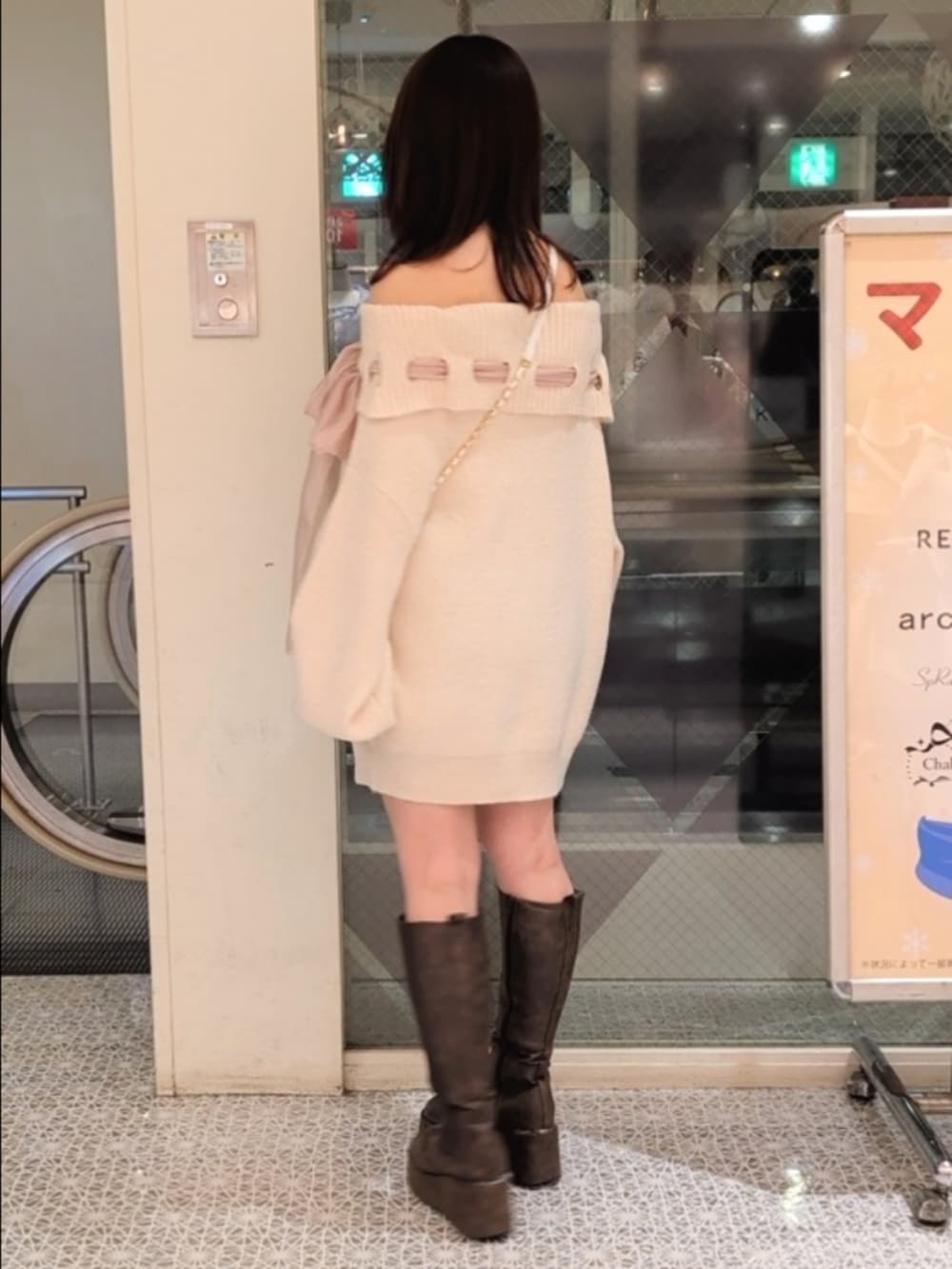 ピンク系のワンピース、ホワイト系のショルダーバッグ、ブラウン系のブーツを着用したレディースの冬コーディネートの4枚目の写真