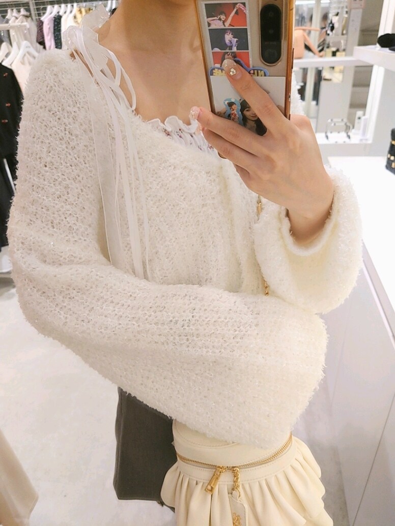 ホワイト系のカーディガン/ボレロ、ホワイト系のキャミソール、グレー系のスカートを着用したレディースの秋コーディネートの4枚目の写真