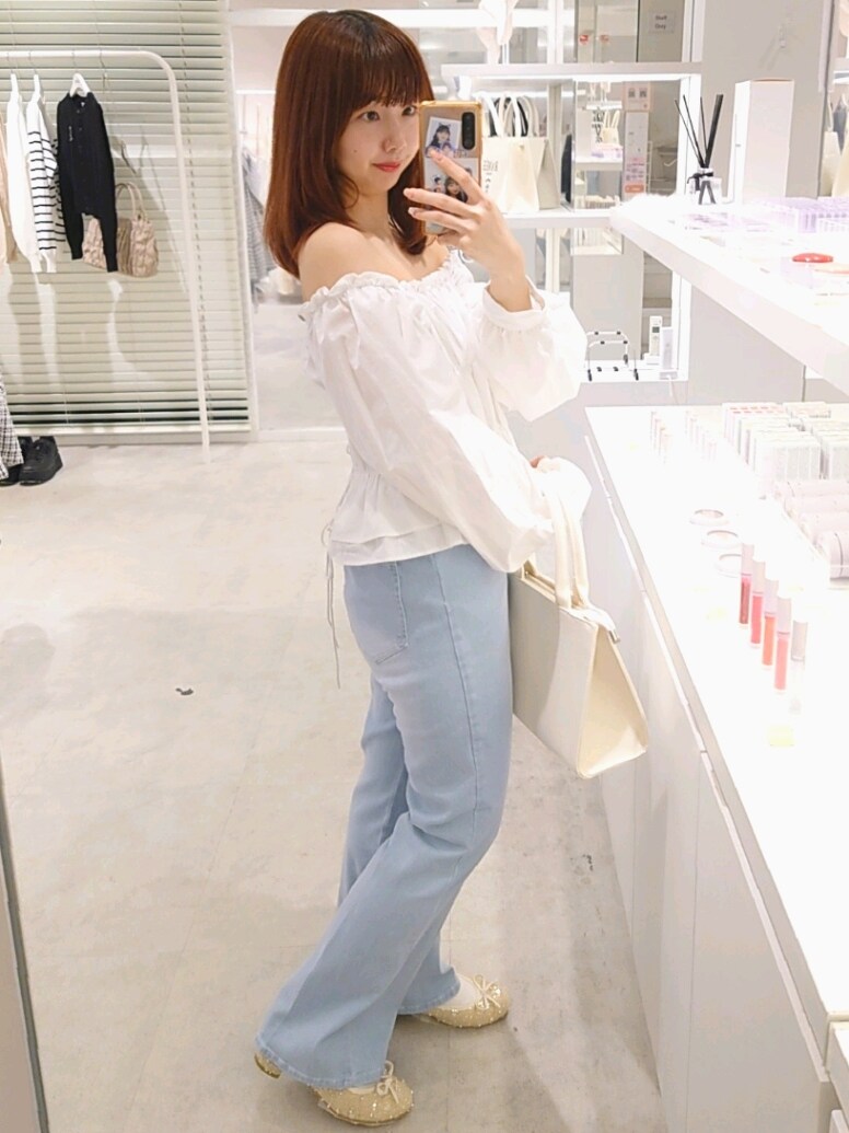 ホワイト系のシャツ/ブラウス、ブルー系のデニムパンツ、ホワイト系のトートバッグを着用したレディースの春コーディネートの3枚目の写真