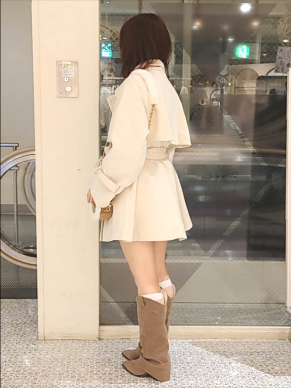 ホワイト系のチェスターコート、ホワイト系のワンピース、ベージュ系のショルダーバッグを着用したレディースの秋コーディネートの4枚目の写真