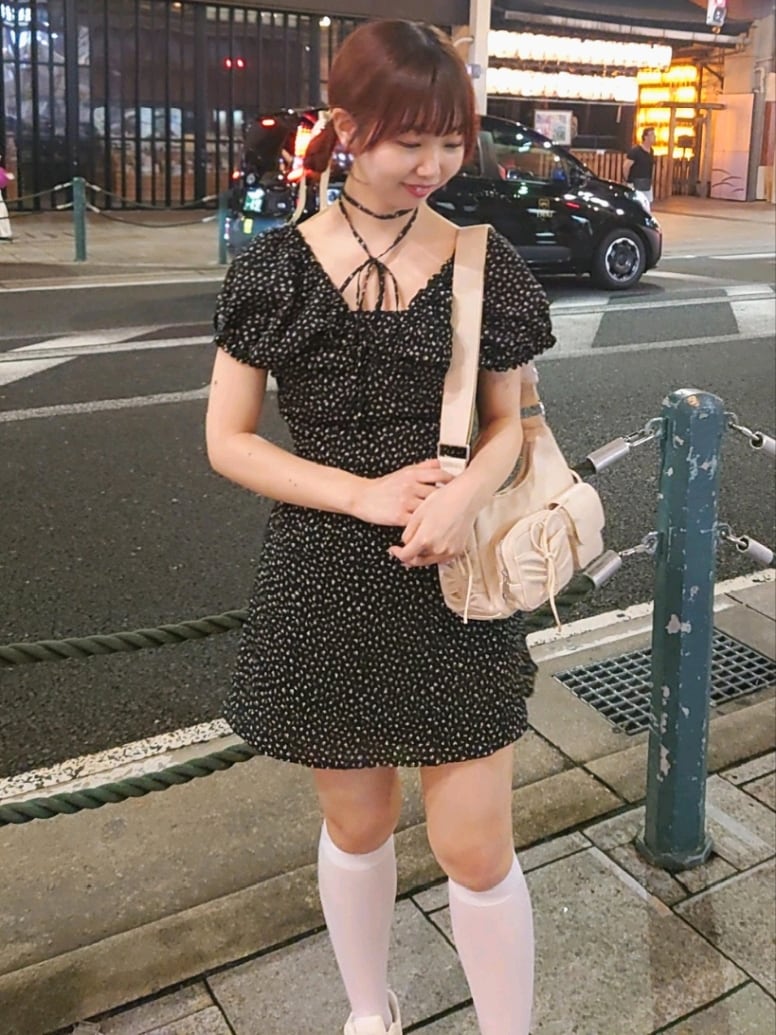 ブラック系のワンピース、ホワイト系のショルダーバッグ、ホワイト系のスニーカーを着用したレディースの夏コーディネートの2枚目の写真