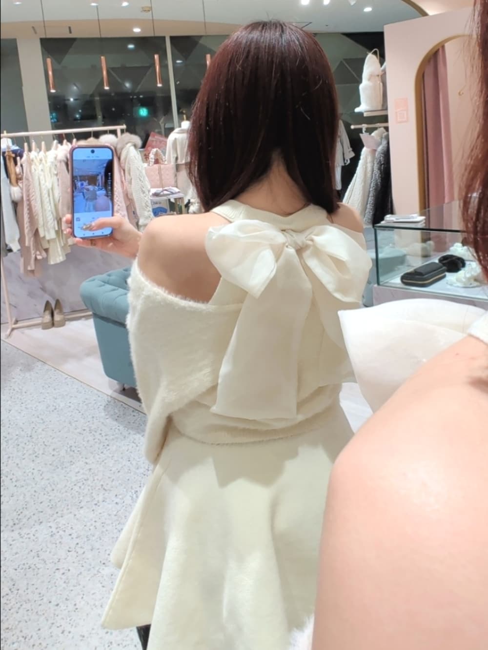 ホワイト系のワンピース、ブラック系のトートバッグ、ブラック系のパンプスを着用したレディースの冬コーディネートの3枚目の写真