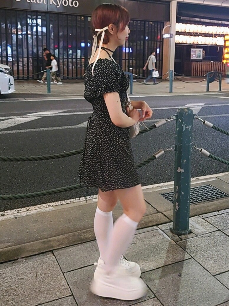 ブラック系のワンピース、ホワイト系のショルダーバッグ、ホワイト系のスニーカーを着用したレディースの夏コーディネートの3枚目の写真